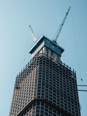 High-rise building under construction with cranes.